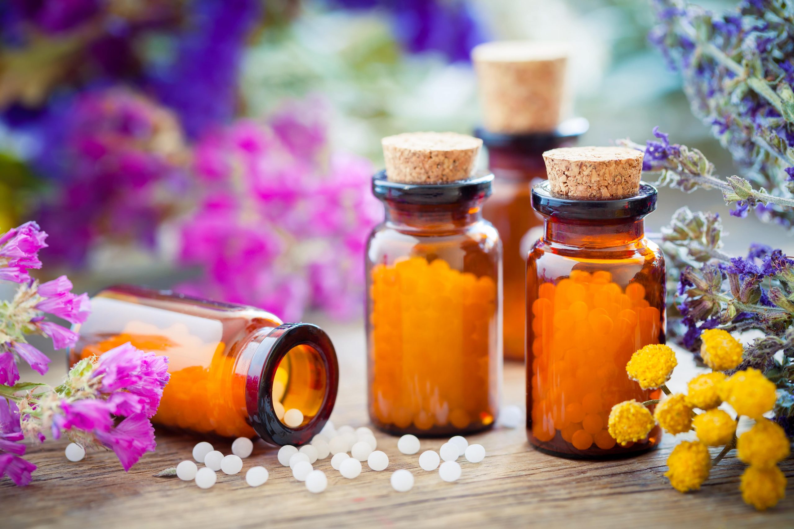 Pills in flask sorounded by herbs and spices